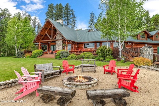 271 W Shore Ln, Sandpoint, ID 83864 - rear view of house featuring a fire pit, log exterior, metal roof, a yard, and a chimney