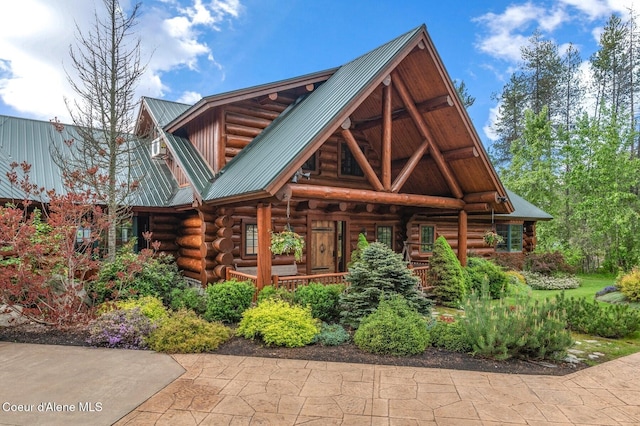 271 W Shore Ln, Sandpoint, ID 83864 - view of front facade with log exterior, a porch, and metal roof