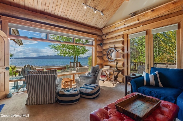 271 W Shore Ln, Sandpoint, ID 83864 - carpeted living area with rail lighting, wood ceiling, rustic walls, plenty of natural light, and a water view