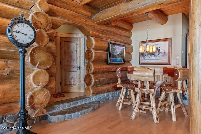 271 W Shore Ln, Sandpoint, ID 83864 - dining room featuring wooden ceiling with exposed beams, wood finished floors, a chandelier, and log walls