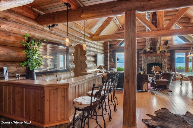 271 W Shore Ln, Sandpoint, ID 83864 - kitchen with rustic walls, open floor plan, hardwood / wood-style floors, wooden ceiling, and a stone fireplace