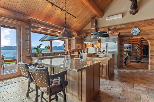 271 W Shore Ln, Sandpoint, ID 83864 - kitchen with an island with sink, wood ceiling with exposed beams, arched walkways, rustic walls, and a wall mounted air conditioner