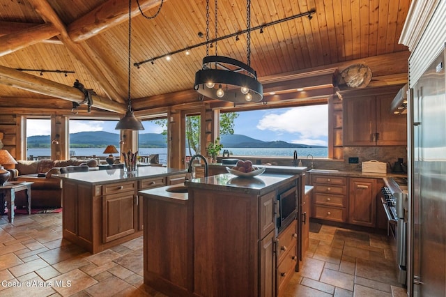 271 W Shore Ln, Sandpoint, ID 83864 - kitchen with wood ceiling with exposed beams, a center island with sink, stainless steel appliances, track lighting, and a sink