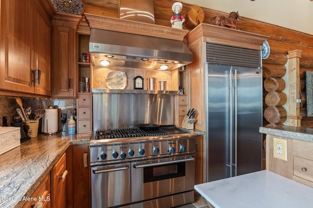 271 W Shore Ln, Sandpoint, ID 83864 - kitchen featuring premium appliances, extractor fan, brown cabinets, backsplash, and log walls