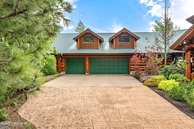 271 W Shore Ln, Sandpoint, ID 83864 - log cabin with log siding, driveway, a garage, and metal roof