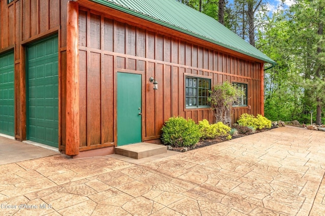 271 W Shore Ln, Sandpoint, ID 83864 - view of exterior entry with board and batten siding, a garage, and metal roof