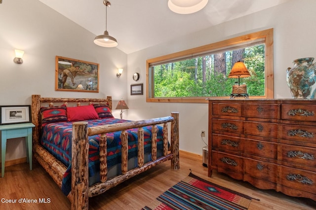 271 W Shore Ln, Sandpoint, ID 83864 - bedroom featuring vaulted ceiling, multiple windows, wood finished floors, and baseboards