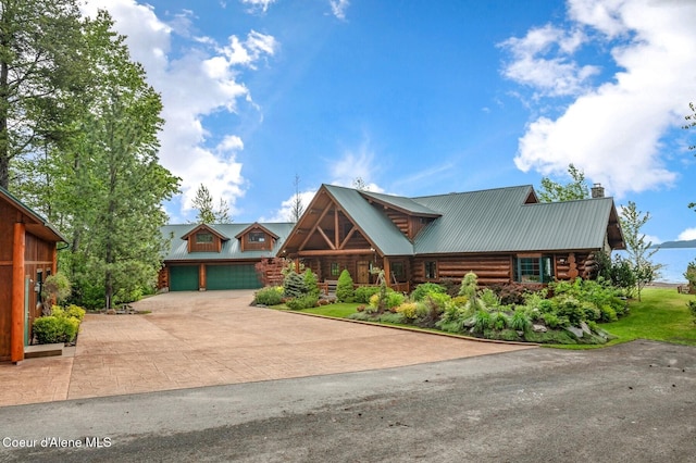 271 W Shore Ln, Sandpoint, ID 83864 - log-style house featuring log siding, a chimney, metal roof, and decorative driveway