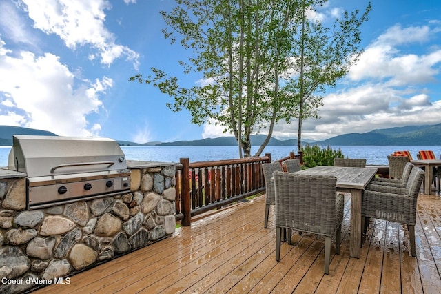 271 W Shore Ln, Sandpoint, ID 83864 - wooden terrace featuring area for grilling, a water and mountain view, and outdoor dining space