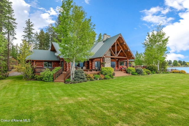 271 W Shore Ln, Sandpoint, ID 83864 - back of house with log exterior, a yard, a chimney, and metal roof