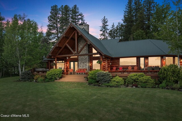 271 W Shore Ln, Sandpoint, ID 83864 - rear view of house featuring a chimney, a wooden deck, a lawn, and log siding