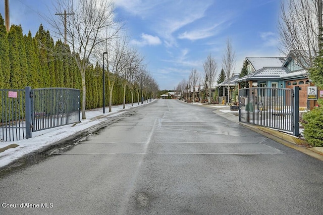 4362 N Meadow Ranch Ave, Coeur Dalene, ID 83815 - view of asphalt street with a gate, curbs, street lighting, and sidewalks