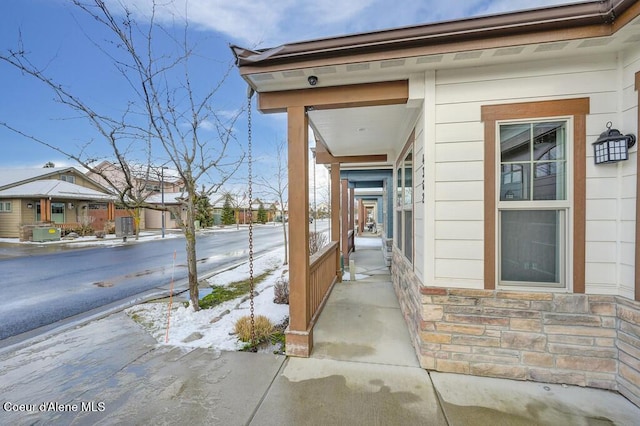 4362 N Meadow Ranch Ave, Coeur Dalene, ID 83815 - snow covered property entrance with stone siding and covered porch