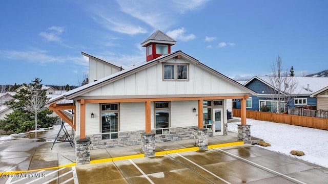 4362 N Meadow Ranch Ave, Coeur Dalene, ID 83815 - view of front of house featuring board and batten siding, covered porch, fence, and stone siding