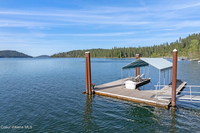 dock area featuring a water view and a wooded view