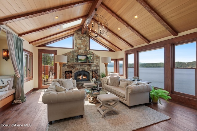 living area featuring a water view, beam ceiling, wooden ceiling, wood finished floors, and a fireplace