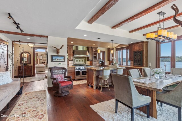 dining area with dark wood-type flooring, beamed ceiling, recessed lighting, and a water view