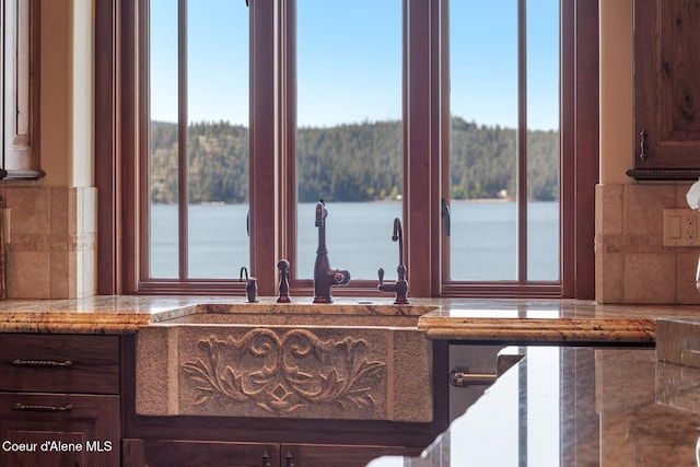 kitchen featuring plenty of natural light, backsplash, and light stone countertops
