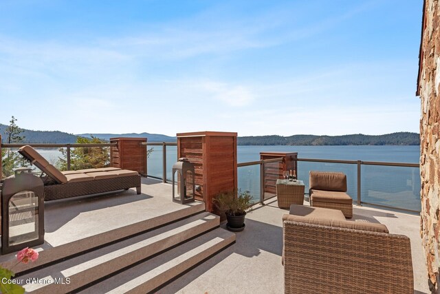 view of patio / terrace featuring a water and mountain view