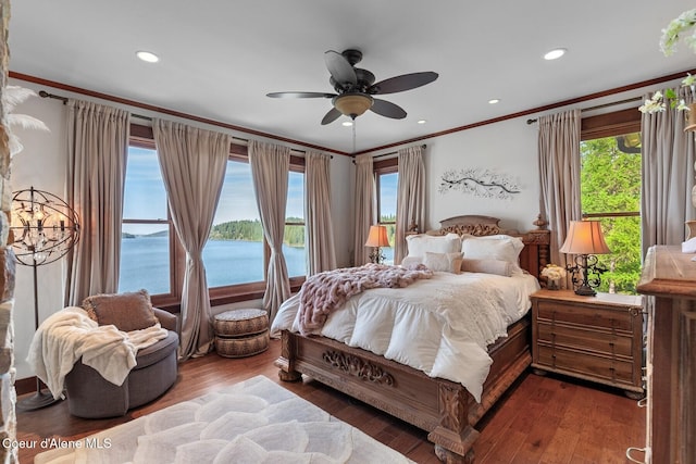 bedroom with ornamental molding, a water view, wood finished floors, recessed lighting, and ceiling fan