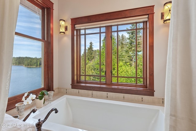 bathroom featuring a garden tub and a water view