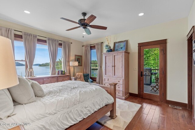 bedroom with access to outside, baseboards, hardwood / wood-style floors, multiple windows, and recessed lighting