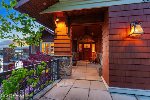 property entrance with stone siding and a porch