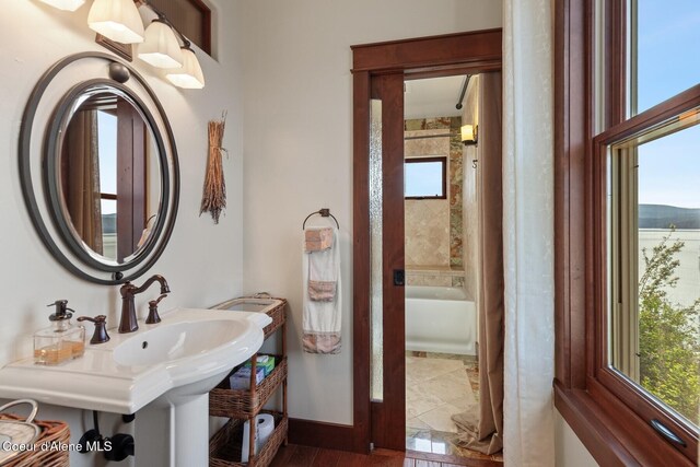 full bathroom with a sink and baseboards