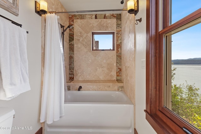 bathroom with shower / bathtub combination with curtain and toilet