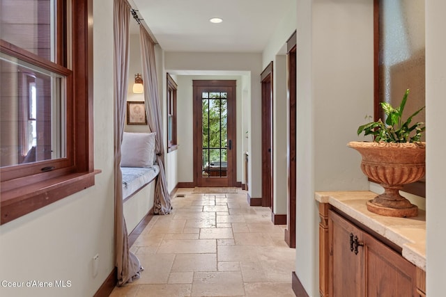 entryway with baseboards, stone tile floors, and recessed lighting