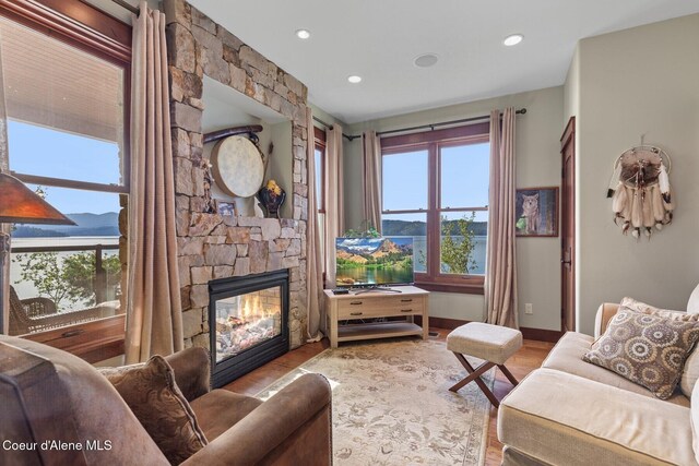 living area with a fireplace, wood finished floors, and recessed lighting