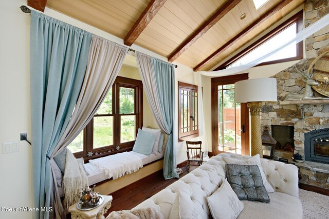 living room featuring plenty of natural light, a fireplace, wood ceiling, wood finished floors, and baseboards