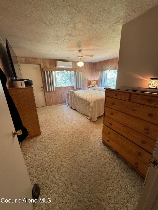 295 A St, Sandpoint, ID 83864 - carpeted bedroom with a wall mounted AC, a textured ceiling, wooden walls, multiple windows, and a ceiling fan