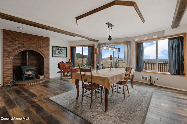 1341 Merideth Rd, Plummer, ID 83851 - dining room featuring a wood stove, beam ceiling, wood finished floors, and baseboards