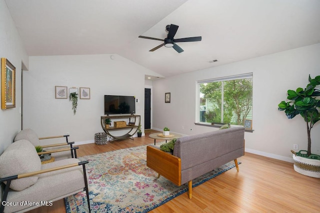 living room featuring lofted ceiling, ceiling fan, wood finished floors, and baseboards