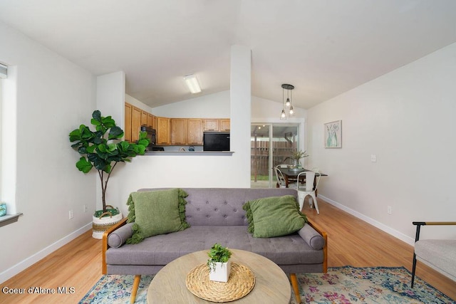 living room with light wood-style floors, lofted ceiling, and baseboards