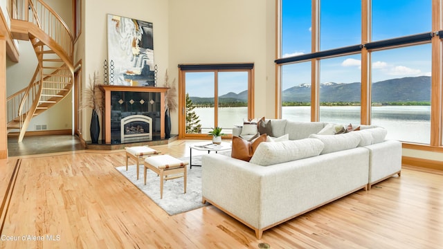 3361 Bottle Bay Rd, Sagle, ID 83860 - living room featuring wood finished floors, a high ceiling, stairway, baseboards, and a water and mountain view