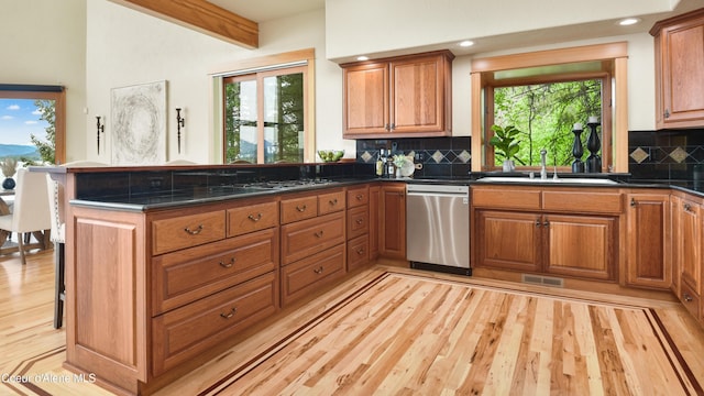 3361 Bottle Bay Rd, Sagle, ID 83860 - kitchen with stainless steel appliances, a peninsula, a sink, light wood-style floors, and brown cabinets