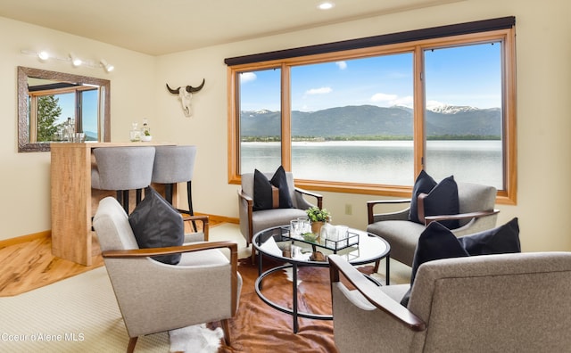 3361 Bottle Bay Rd, Sagle, ID 83860 - living room featuring baseboards, a water and mountain view, and wood finished floors