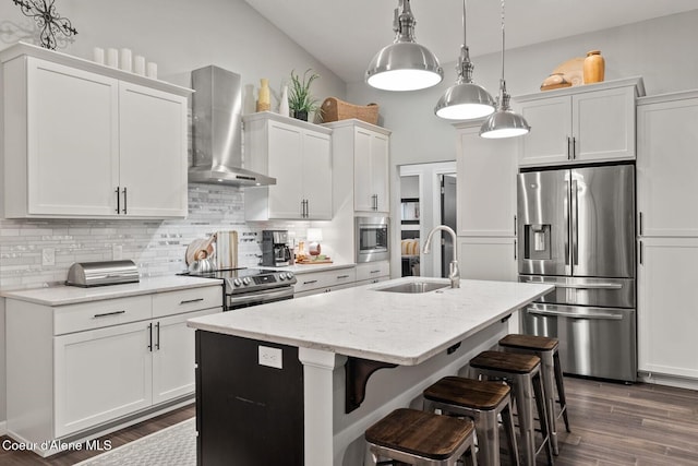 990 Goldfinch Ln, Spirit Lake, ID 83869 - kitchen featuring appliances with stainless steel finishes, a sink, wall chimney exhaust hood, a center island with sink, and tasteful backsplash