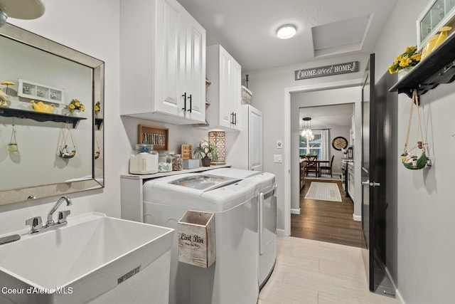 990 Goldfinch Ln, Spirit Lake, ID 83869 - clothes washing area featuring washing machine and dryer, cabinet space, and baseboards