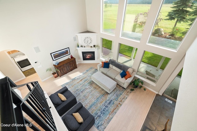 22385 N Ranch View Dr, Rathdrum, ID 83858 - living area with high vaulted ceiling, plenty of natural light, a glass covered fireplace, baseboards, and wood finished floors