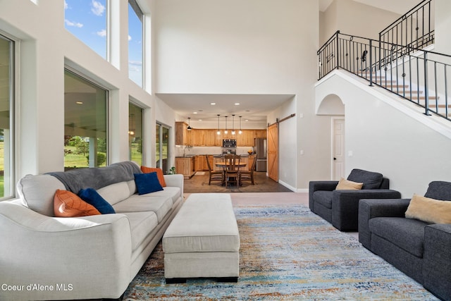 22385 N Ranch View Dr, Rathdrum, ID 83858 - living room with a high ceiling, a barn door, stairway, arched walkways, and baseboards