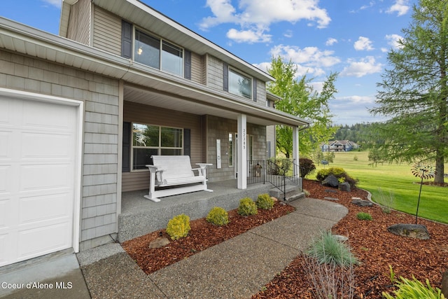 22385 N Ranch View Dr, Rathdrum, ID 83858 - entrance to property with a porch, a yard, and an attached garage