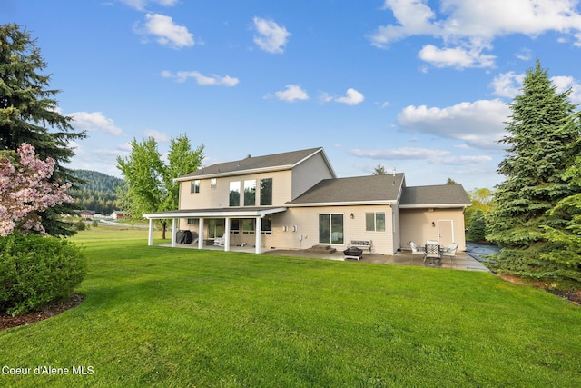 22385 N Ranch View Dr, Rathdrum, ID 83858 - back of property with a patio area and a lawn