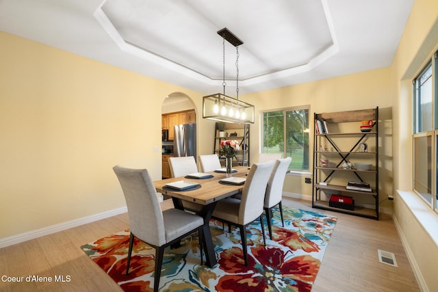 22385 N Ranch View Dr, Rathdrum, ID 83858 - dining area with a tray ceiling, healthy amount of natural light, arched walkways, and light wood-style floors