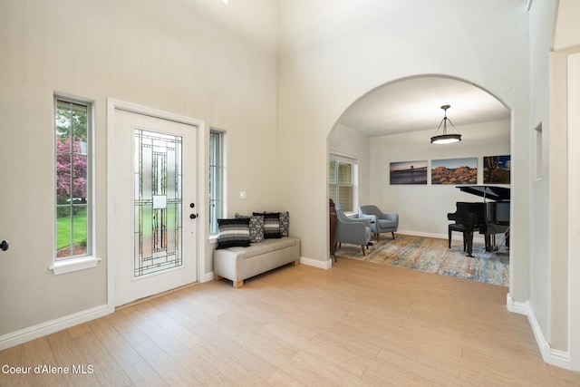 22385 N Ranch View Dr, Rathdrum, ID 83858 - entryway featuring arched walkways, light wood-type flooring, a towering ceiling, and baseboards