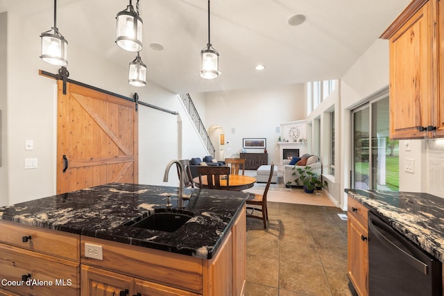 22385 N Ranch View Dr, Rathdrum, ID 83858 - kitchen featuring a sink, dishwashing machine, a barn door, a center island, and dark stone counters