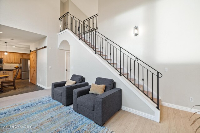 22385 N Ranch View Dr, Rathdrum, ID 83858 - staircase featuring a barn door, a high ceiling, wood finished floors, arched walkways, and baseboards