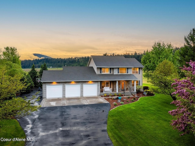 22385 N Ranch View Dr, Rathdrum, ID 83858 - view of front facade with covered porch, driveway, a yard, and a garage